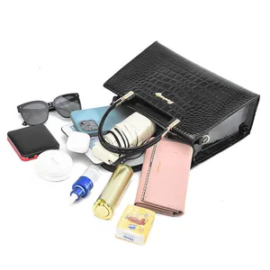 Capacity view of black crocodile pattern handbag showing essentials like phone and umbrella