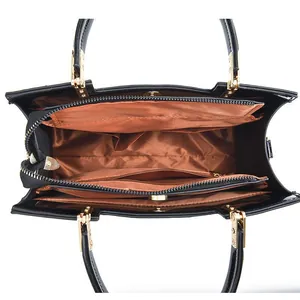 Interior view of black glossy handbag showing multi-compartment layout and tan lining