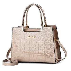 Detailed macro view of champagne patent leather handbag with crocodile pattern texture