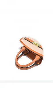 Dettaglio elegante borsa in pelle bicolore con chiusura dorata e trama martellata