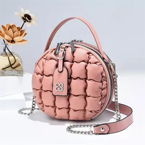 Detailaufnahme der Stepptextur und des Doppelreißverschlusses der runden rosa Tasche