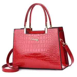 Red shiny crocodile embossed leather handbag with top handles and shoulder strap
