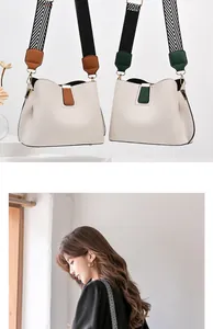 Detail of bucket bag with pebbled leather texture and patterned wide shoulder strap