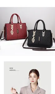 Detail of red and black tote bags with wing-shaped charms and gold-tone hardware
