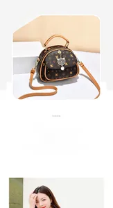 Close-up of vintage brown monogrammed crossbody bag with cute cat metal pendant