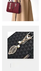 Detail of elegant handbag with triangle texture, metal leaf charm and pearl tassel