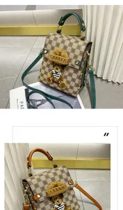 Détail d'un sac à damier avec un ours en peluche 3D et une poignée supérieure verte