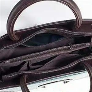 Detail view showing multi-layer interior compartments and zipper closure of the tote bag