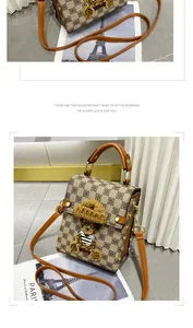 Gros plan du sac à damier avec un écusson ours en peluche 3D et des clous en métal