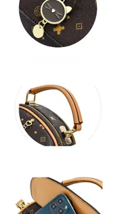 Detail of printed handbag showing front phone pocket and golden cat charm on brown leather