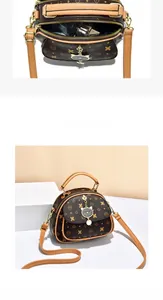 Detail of cartoon monogram handbag showing double zipper compartments and cat charm