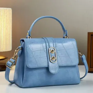Detailansicht hellblaue Krokostil-Handtasche mit Metallringverschluss und Tragegriff