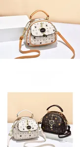 Detail of cartoon printed crossbody bag with bear motif and cat shaped metal charm