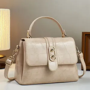 Elegante beige Handtasche mit Krokodilprägung, Goldbeschlägen und Trageriemen