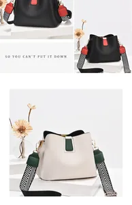 Detail of lychee textured bucket bag featuring wide woven chevron shoulder strap and buckle