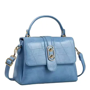 Elegante blaue Handtasche mit Krokodilmuster, Goldbeschlägen und Tragegriff
