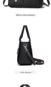 Side view of black faux leather wing bag with dark brown strap and gold metal hardware