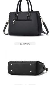 Detail view of black handbag showing back zipper pocket and metal feet on the bottom