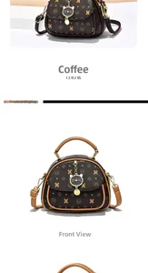 Detail of dark brown vintage monogram handbag with cat-shaped metal pendant and leather handle