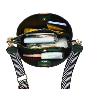 Dark green leather bucket bag with wide woven strap showing spacious interior storage