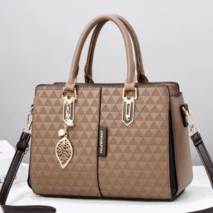 Brown winged tote bag with geometric triangle texture and pearl leaf charm detail