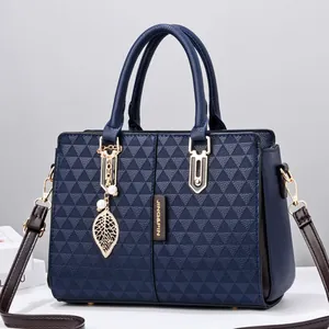 Navy blue wing tote bag with geometric triangle embossing and gold leaf charm
