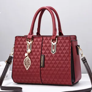 Burgundy quilted wing-shaped handbag with leaf charm and gold-tone hardware