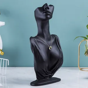 Detail van zwarte hars mannequin sieradenstandaard met gouden halsketting display