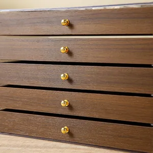 Detail of 5-tier walnut wood jewelry box with clear acrylic walls and gold metal knobs