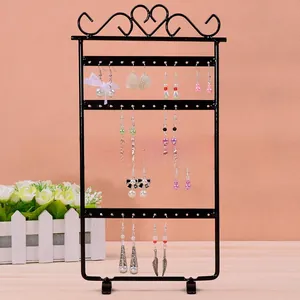 Detail of 4-tier black metal earring stand featuring 48 holes and heart scroll design
