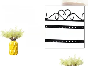Detail view of 48-hole black iron earring organizer with decorative heart top design