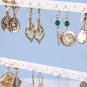 Detail showing 925 sterling silver hooks on gold geometric earrings with green beads