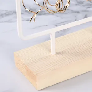 Detail of earring display stand with light wood base and white iron frame structure