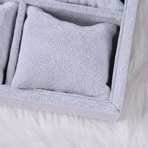 Nahaufnahme der grauen Samt-Schmucklade mit weichen Kissen für Uhren und Armbänder