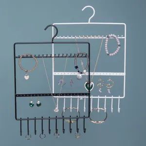 Close-up of wall-mounted iron jewelry rack with multi-tier hooks for earrings and necklaces