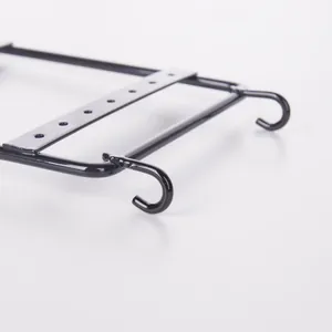 Detail of black iron jewelry organizer rack showing metal hooks and earring hanging holes