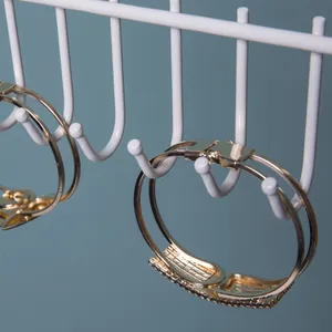 Detail of gold double-layer hinged bracelet with crystal rectangle on display rack