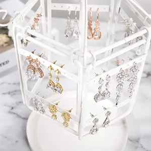 Detailed view of white rotating metal earring stand displaying various crystal drops