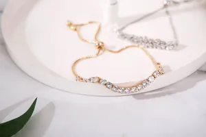 Detail of adjustable gold and silver bracelets featuring brilliant cubic zirconia stones