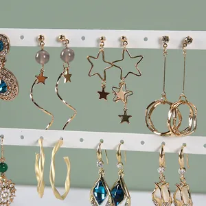 Vue détaillée de divers bijoux d'oreilles sur un présentoir à trois niveaux en fer blanc