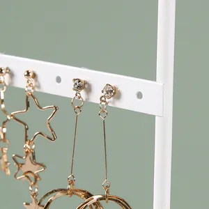 Support à boucles d'oreilles doré à trois niveaux avec modèles étoiles et glands
