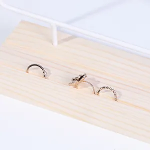 Detailansicht goldener Ringe mit Blumen- und Herzmotiven auf einem Holzdisplay