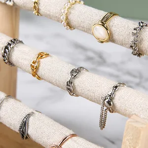 Golden and silver jewelry rings displayed on a premium 3-tier linen wood jewelry stand