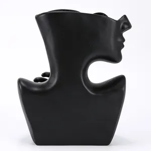 Macro view of matte black abstract face vase with modern minimalist sculpture details
