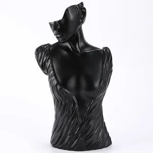 Detail of matte black resin female bust statue showing artistic garment textures