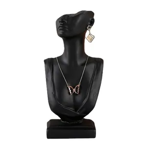 Resin bust display stand featuring butterfly pendant necklace and geometric earrings