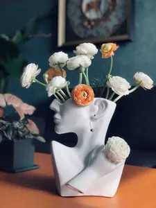 Creative white ceramic face profile vase with golden earring jewelry and silk flowers