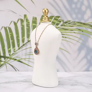 Dettaglio della collana vintage con ciondolo a goccia blu su un busto bianco da esposizione