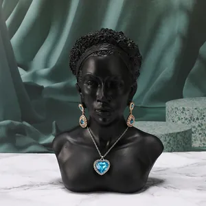 Dettaglio della collana con gemma blu a cuore su un supporto per gioielli nero