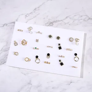 Collection of golden jewelry with pearls and gems on a professional white display grid